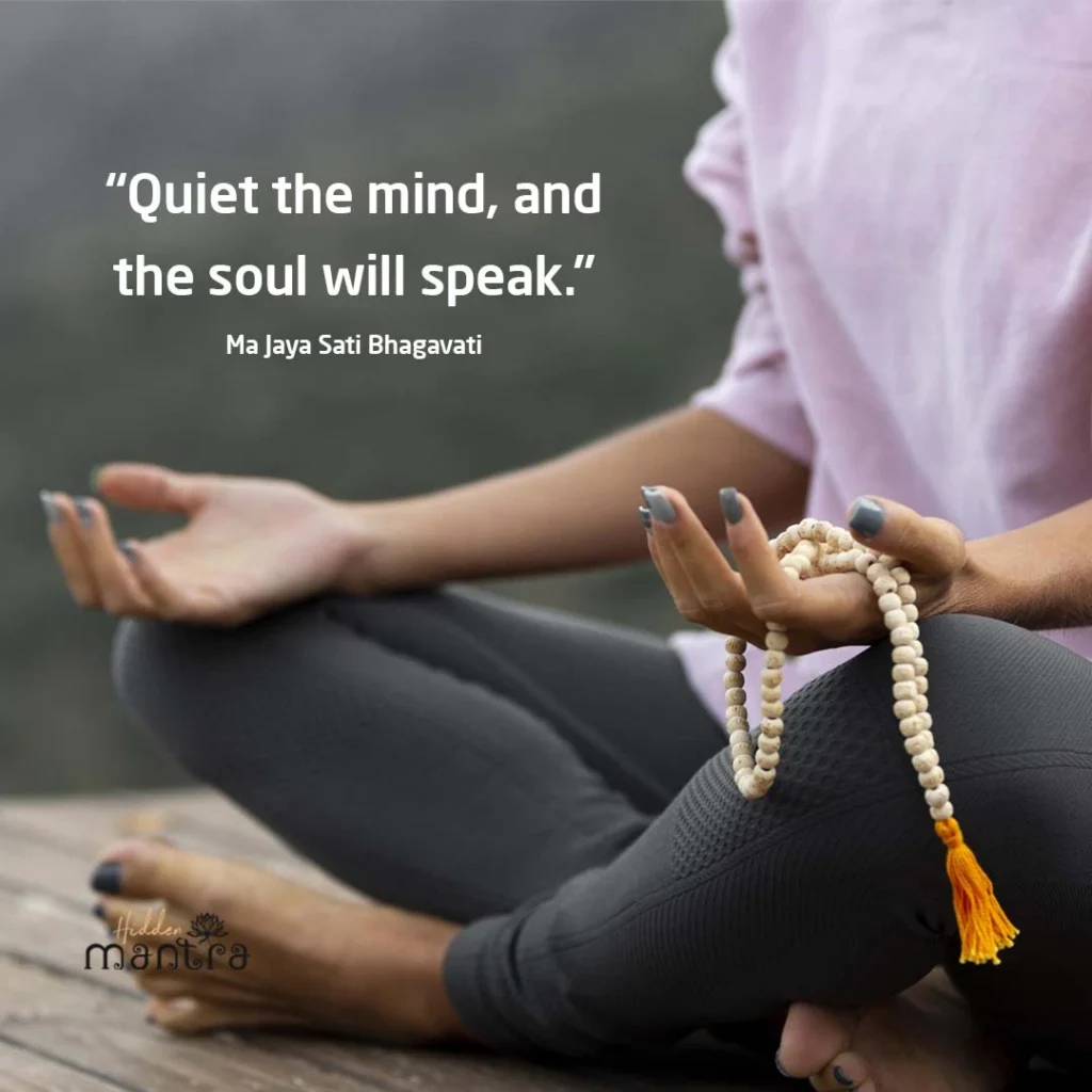 Inspirational yoga and meditation quote “Quiet the mind, and the soul will speak” with woman meditating while holding mala beads.