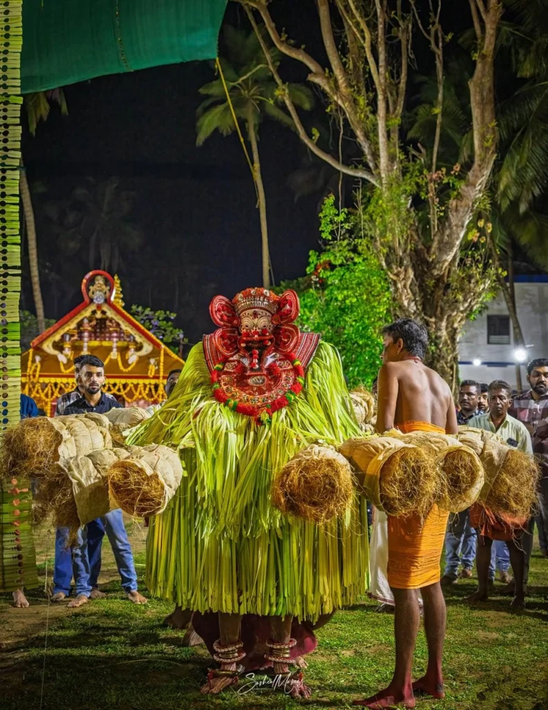 Kandakarnan Theyyam performer in traditional costume preparing for a nighttime ritual at a village shrine in Kannur, Kerala.