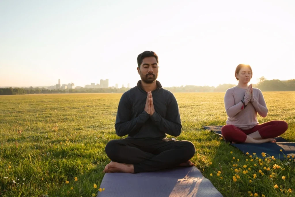 Person sitting cross-legged in meditation posture with eyes closed, practicing beginner meditation